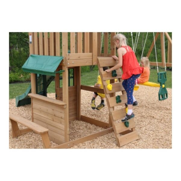 Kidkraft Windale Fort outdoor swing set featuring a wooden fort, swings, and a slide in a backyard setting.